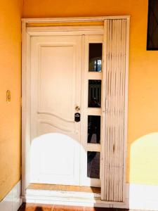 una puerta blanca en una pared amarilla en Mi Casa en Rio, en Riobamba