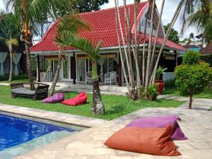 a house with colorful pillows in front of a swimming pool at Le Kekeri Villas Collection in Mataram