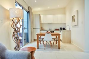 a kitchen and dining room with a table and chairs at Arajilla Retreat in Lord Howe
