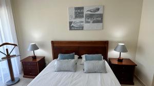 um quarto com uma cama com 2 mesas de cabeceira e 2 candeeiros em Charmant appartement a 1km de la plage, avec piscine a Albufeira em Albufeira