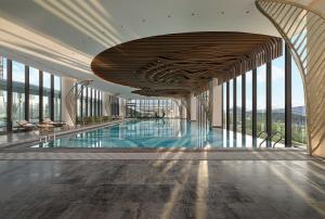 a large swimming pool in a building with windows at The Westin Yantai in Yantai