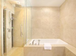 a bathroom with a tub and a shower at Four Points by Sheraton Manado in Manado