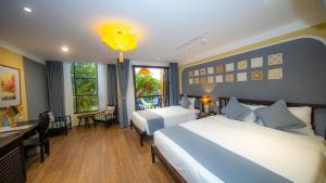 um quarto de hotel com uma cama e uma secretária e um quarto em Hoianan Boutique Hotel em Hoi An