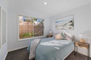 1 dormitorio con cama y ventana en Seascape at Cape, en Cape Paterson