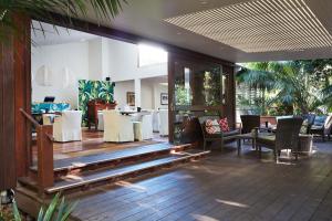 un restaurante con mesas y sillas blancas en una habitación en Arajilla Retreat en Lord Howe