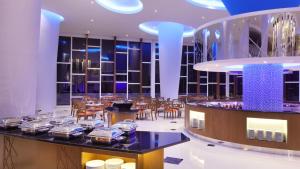 - un restaurant avec des tables et des chaises dans une salle dans l'établissement Four Points by Sheraton Manado, à Manado
