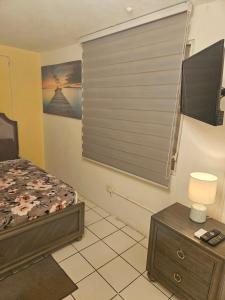 1 dormitorio con ventana, cama y mesa en Relaxing Tropical Studio, en San Juan