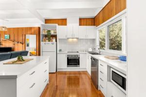 a kitchen with white appliances and wooden cabinets at Seabreeze at silverleaves in Rhyll