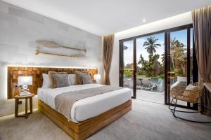 a bedroom with a large bed and a balcony at Villa Pearl by BaliSuperHost in Ubud