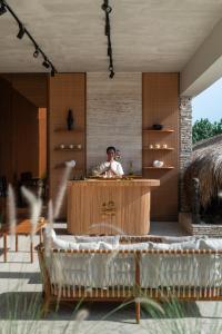 een man staat aan een toonbank in een huis bij Cap Karoso Sumba - a member of Design Hotels 