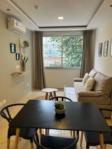 a living room with a table and a couch at Dptos Corrientes con cochera in Corrientes