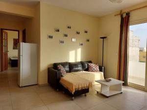 ein Wohnzimmer mit einem Sofa und einem Kühlschrank in der Unterkunft OKEANOS in Sal Rei