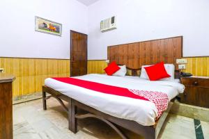 - une chambre avec un grand lit et des oreillers rouges dans l'établissement Flagship Hotel Prem Chunaria, à Moradabad