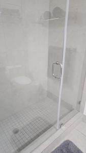 uma casa de banho com um chuveiro e uma porta de vidro em 5350 Park inn Suite em Miami