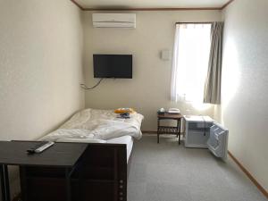 a hospital room with a bed and a television at Yasuragino Yado -Iyashino Yu- in Kitakami