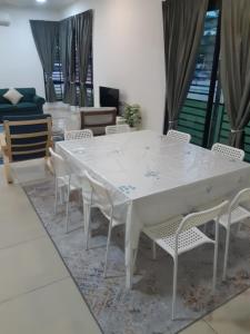 uma mesa branca e cadeiras numa sala de estar em Gallery@U12Homestay em Shah Alam