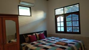a bedroom with a bed and a window at Risal Guest House in Munggu