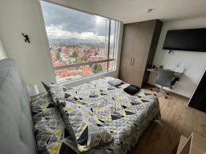 1 dormitorio con cama y ventana grande en Apartaestudio/Loft - Último Piso - Hermosa Vista, en Bogotá