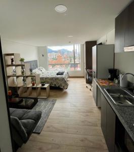 cocina y sala de estar con cama de fondo en Apartaestudio/Loft - Último Piso - Hermosa Vista, en Bogotá