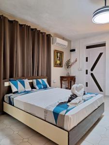 1 dormitorio con 1 cama grande con almohadas azules en R Garden Studio 1 - Ensuite avec accès privé et indépendant, en Baie du Tombeau