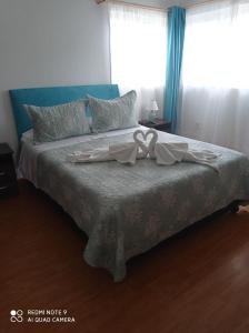 Una cama con un vestido en un dormitorio en HOSTAL SUITE 1 Oriente 1075, Viña del Mar, en Viña del Mar