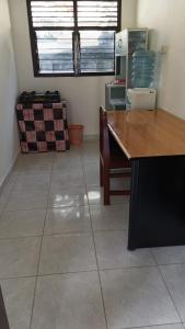 a kitchen with a table and a tile floor at Risal Guest House in Munggu