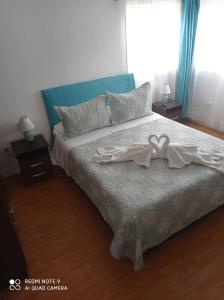 a bedroom with a bed with a bow on it at HOSTAL SUITE 1 Oriente 1075, Viña del Mar in Viña del Mar