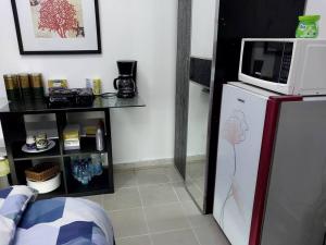 a kitchen with a microwave on top of a refrigerator at Private Bedroom in a Home With Park View in Sharjah