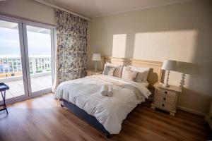 ein Schlafzimmer mit einem Bett und einem großen Fenster in der Unterkunft Salt House in Kapstadt