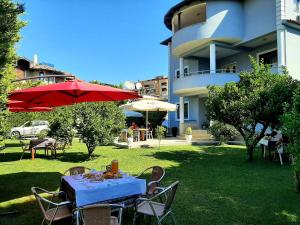 una mesa con sombrilla roja y sillas en un patio en Hotel Vila Arbri, en Berat