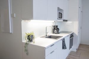 een keuken met witte kasten en een wastafel bij Snowflake Suites II in Rovaniemi