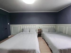 ソギポにあるPyoLi Guesthouseのベッドルーム1室(隣り合わせのベッド2台付)