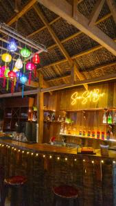 eine Bar in einem Restaurant mit Lichtern darüber in der Unterkunft MUINE SUN & SEA BEACH ( BOUTIQUE RESORT & GLAMPING) in Mui Ne
