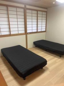 2 camas en una habitación con ventanas en 最大２２名BBQ.サウナ.カラオケ.ビリヤード.卓球付き! en Nasu-yumoto