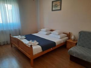 a bedroom with a bed and a couch and a chair at Pansion Dovodja in Vodice