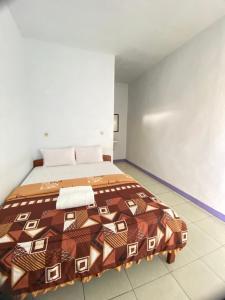 a bedroom with a large bed in a room at Mahoni Guest House in Kelimutu