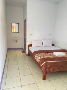 - une chambre avec un lit et un lavabo dans l'établissement Mahoni Guest House, à Kelimutu