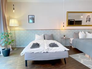 1 Schlafzimmer mit 2 Betten und einem Spiegel in der Unterkunft presence: grosszüges Loft_ bis 6 Pers_zentral in Luzern