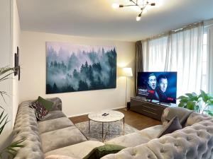 ein Wohnzimmer mit einem Sofa und einem Flachbild-TV in der Unterkunft presence: grosszüges Loft_ bis 6 Pers_zentral in Luzern