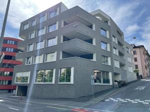 ein graues Gebäude auf einer Straße mit einer Straße in der Unterkunft presence: grosszüges Loft_ bis 6 Pers_zentral in Luzern