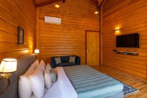 a bedroom with a bed and a tv in a room at StayVista at Villa Vivendi - 4 BR villa in Dharamshala in Dharamshala