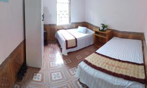 Habitación pequeña con 2 camas y ventana en Hong Minh Guesthouse en Mù Cang Chải