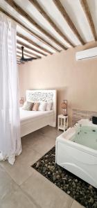 1 dormitorio con cama y bañera en ARYA Boutique Resort en Kiwengwa