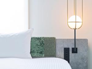 a bedroom with a white bed and a lamp at Mitsui Garden Hotel Ueno - Tokyo Reopened in July 2023 in Tokyo