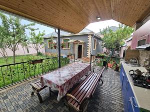 patio con mesa y bancos en el balcón en Elnr Small swing pool villa, en Daşca