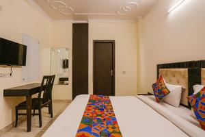新德里的住宿－FabHotel Gera，一间卧室配有一张床、一张桌子和一张桌子