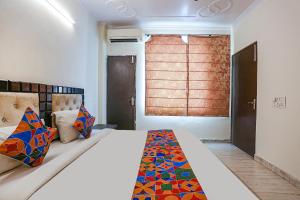 - une chambre avec un grand lit et une fenêtre dans l'établissement FabHotel Gera, à New Delhi