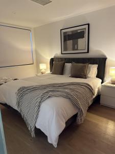 - une chambre avec un grand lit et une couverture dans l'établissement Palko - Luxury In the City, à Canberra