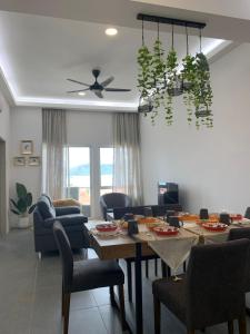 Simfoni Resort Langkawi في كواه: غرفة معيشة مع طاولة وكراسي وسقف