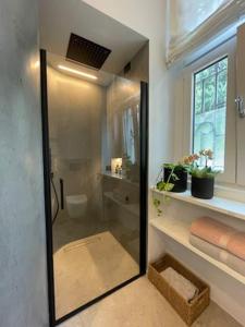 uma casa de banho com um chuveiro e uma porta de vidro em Civico29 appartamento bilocale em Como